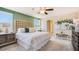 Main bedroom with a king-size bed, green accent wall, and plenty of natural light at 5322 Oxford Gray Rd, Wesley Chapel, FL 33545