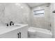 Updated bathroom with white vanity, tub, and marble-look tile at 5712 17Th N Ave, St Petersburg, FL 33710