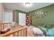 Charming Bedroom features a crib, armchair, and bookcase at 5720 107Th E Ter, Parrish, FL 34219