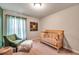 Neutral Bedroom with a crib, armchair and window with sheer curtains at 5720 107Th E Ter, Parrish, FL 34219