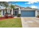 Single-story house with gray siding, blue garage door, and landscaped yard at 5720 107Th E Ter, Parrish, FL 34219