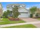 Two-story house with gray siding, brick driveway, and landscaping at 6205 Voyagers Pl, Apollo Beach, FL 33572