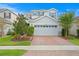 Two story house with a white garage door and landscaping at 6205 Voyagers Pl, Apollo Beach, FL 33572