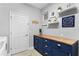 Laundry room with blue cabinets, wood countertop, and built-in shelving at 6205 Voyagers Pl, Apollo Beach, FL 33572