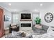 Cozy living room with fireplace, large sectional sofa, and wood accent wall at 6205 Voyagers Pl, Apollo Beach, FL 33572