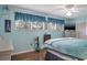 Bedroom with large bed, ceiling fan, and light blue walls at 6432 Remus Dr, New Port Richey, FL 34653