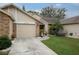 Tan townhouse with brick accents, landscaped lawn, and attached garage at 6432 Remus Dr, New Port Richey, FL 34653