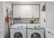 Laundry room with Samsung washer and dryer, and overhead cabinets at 6432 Remus Dr, New Port Richey, FL 34653