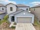 Two-story house with gray exterior, two-car garage, and landscaping at 656 Argyll Dr, Spring Hill, FL 34609