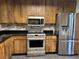 Modern kitchen featuring stainless steel appliances and beautiful wooden cabinetry at 7806 Amberlea Ct, Temple Terrace, FL 33637