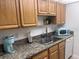 Galley kitchen with granite countertops and wood cabinets at 8101 113Th Street St # 107, Seminole, FL 33772