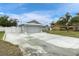 House with gray exterior, two-car garage, and a large concrete driveway at 10448 Utah St, Spring Hill, FL 34608