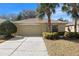 Tan house with a two-car garage and landscaping at 10833 Collar Dr, San Antonio, FL 33576