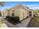 Tan house with walkway and lush landscaping at 10833 Collar Dr, San Antonio, FL 33576