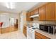 Kitchen with wood cabinets, white appliances, and a breakfast nook at 10833 Collar Dr, San Antonio, FL 33576
