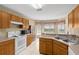 Kitchen with wood cabinets, white appliances, and a breakfast nook at 10833 Collar Dr, San Antonio, FL 33576