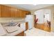 Kitchen with wood cabinets, white appliances, and a breakfast nook at 10833 Collar Dr, San Antonio, FL 33576