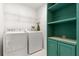 Laundry room with washer, dryer, shelving, and extra storage at 10833 Collar Dr, San Antonio, FL 33576