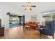 Living room with wood floors, comfy furniture, and access to a screened patio at 10833 Collar Dr, San Antonio, FL 33576