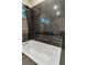 Elegant bathroom with dark tile, soaking tub, and stone feature at 1100 3Rd N St, St Petersburg, FL 33701