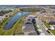 Aerial view of a neighborhood with houses, roads, and a pond at 12143 Kingsley Trl, Parrish, FL 34219