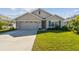 Tan house with a two-car garage and landscaped lawn at 12143 Kingsley Trl, Parrish, FL 34219
