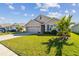 Tan house with a two-car garage and landscaped lawn at 12143 Kingsley Trl, Parrish, FL 34219