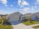 Tan one-story house with gray roof, three-car garage, and solar panels at 12143 Kingsley Trl, Parrish, FL 34219