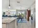 Modern kitchen with breakfast bar, granite counters, and view to dining area at 12143 Kingsley Trl, Parrish, FL 34219