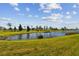 Pond view from backyard with lush greenery at 12143 Kingsley Trl, Parrish, FL 34219