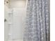 Clean shower with white tile and a patterned shower curtain at 12143 Kingsley Trl, Parrish, FL 34219