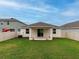 Home exterior showcasing a covered patio and fenced backyard at 16732 Mooner Plank Cir, Wimauma, FL 33598