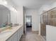 Main bathroom features a double vanity, shower and bedroom access at 16732 Mooner Plank Cir, Wimauma, FL 33598