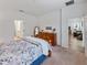 Spacious bedroom with a dresser, large bed and access to another room at 16732 Mooner Plank Cir, Wimauma, FL 33598