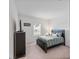 Spacious bedroom with a queen bed, dresser, and large window at 16732 Mooner Plank Cir, Wimauma, FL 33598
