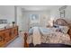 Main bedroom with wooden bed frame, dresser, and large window at 16732 Mooner Plank Cir, Wimauma, FL 33598