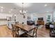 Open concept dining area with a wooden table and chandelier at 16732 Mooner Plank Cir, Wimauma, FL 33598