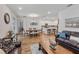 Open concept living area featuring hardwood floors, a leather sofa, and a rustic coffee table at 16732 Mooner Plank Cir, Wimauma, FL 33598