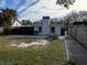 Property's backyard showcases a spacious grassy area, partially fenced at 1824 Douglas Ave, Dunedin, FL 34698