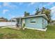 Charming light teal house with a covered patio and well-manicured lawn at 206 N Himes Ave, Tampa, FL 33609