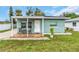 Quaint teal home with covered porch and well-manicured lawn at 206 N Himes Ave, Tampa, FL 33609