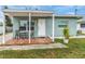 Inviting teal home with covered patio and well-maintained landscaping at 206 N Himes Ave, Tampa, FL 33609