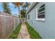 Sidewalk path leading to the backyard, beside a chain-link fence at 206 N Himes Ave, Tampa, FL 33609