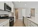 Modern kitchen with white cabinets, stainless steel appliances, and quartz countertops at 2416 Wise River Ln, Zephyrhills, FL 33541