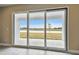 Spacious living area with sliding glass doors offering scenic views of a lake and lush landscape at 2416 Wise River Ln, Zephyrhills, FL 33541