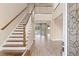 Bright and airy entryway with elegant staircase and wood flooring at 28475 Marsciano Ln, Wesley Chapel, FL 33543