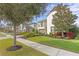 Landscaped home on a tree-lined street with sidewalk at 28475 Marsciano Ln, Wesley Chapel, FL 33543