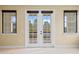 Glass French doors open to a private balcony overlooking a tranquil lake at 28475 Marsciano Ln, Wesley Chapel, FL 33543