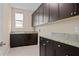 Laundry room with dark brown cabinets and granite countertops at 28475 Marsciano Ln, Wesley Chapel, FL 33543