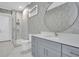 Stylish bathroom with gray vanity and a round mirror at 3213 W Fair Oaks Ave, Tampa, FL 33611